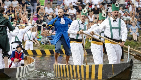 A man who is dressed as a women falls into the water during the Ulm Jousting tournament